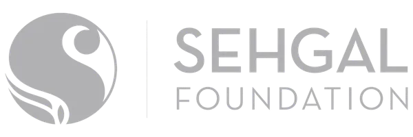 Sehgal Foundation logo featuring a circular emblem with an orange stylized figure and a green leaf motif, next to the text Sehgal Foundation in grey font.